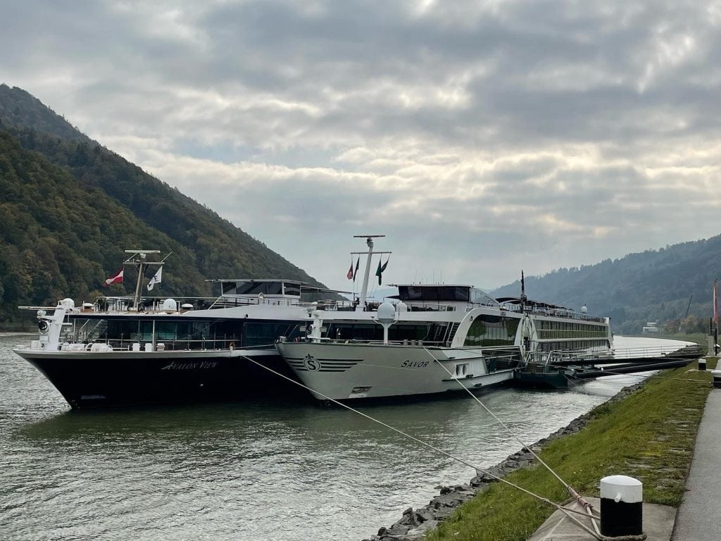Two river cruise ships docked side by side on the Danube in Austria.