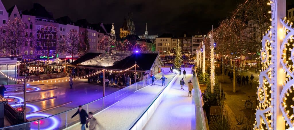 Ice skaters on a lit-up rink at a Christmas market in Cologne, Germany