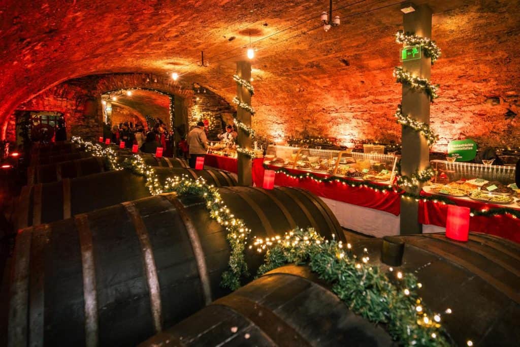 Wine barrels and holiday garlands in a candlelit wine cellar Christmas market